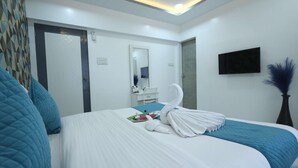 A hotel room with a bed, a TV, a mirror, and a door. - 1 BHK Suite ( Gagal Home) (Mumbai)