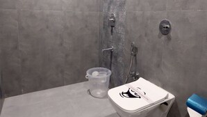 A bathroom with a toilet, a hand soap dispenser, a showerhead, and a handwashing sign. - 1 BHK Suite ( Gagal Home) (Mumbai)
