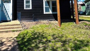 A two-story house with a wooden deck and a blue door.