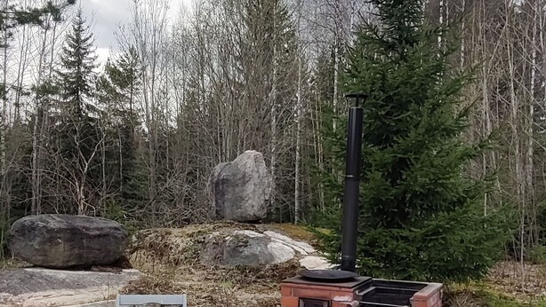 Terassi, jossa on tiililaattalattia, pöytä ja kaksi tuolia.