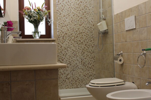 A bathroom with a shower, toilet, and sink.
