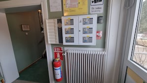 A control panel with multiple switches and a fire extinguisher mounted on the wall.