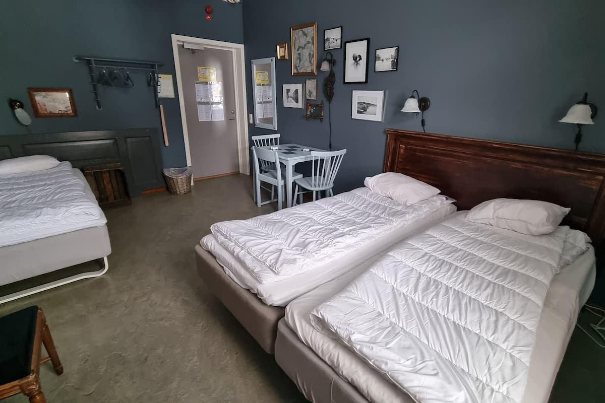 A room with two beds, a desk, and a chair.