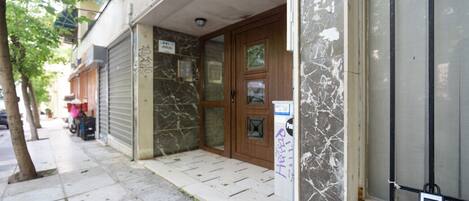 Un edificio con persianas cerradas, una puerta de madera y un cerrojo de seguridad.