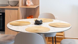 Una cocina moderna con armarios de madera, encimera de mármol y una mesa redonda con individuales tejidos.