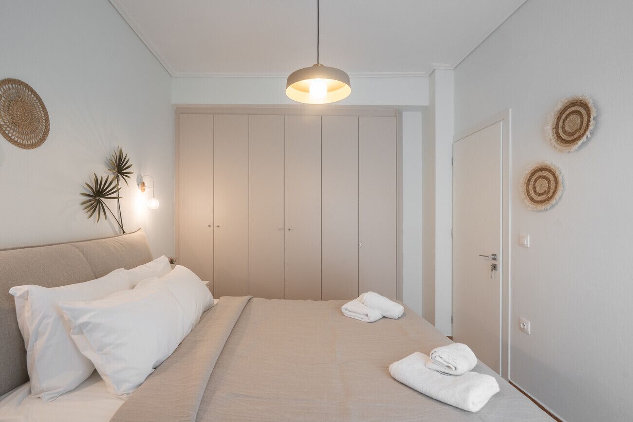 Ein Schlafzimmer mit Bett, Schrank und einer Pendelleuchte.