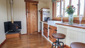 Une cuisine avec des meubles de rangement en bois, une cuisinière, un évier et une fenêtre donnant sur un beau paysage.
