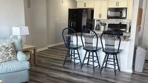 A modern kitchen with white cabinets, a black refrigerator, and a stainless steel stove. - Book Fast! 2BR/2BA Ocean Block—Steps to Beach, Walk to Top Restaurants &! (Ocean City)