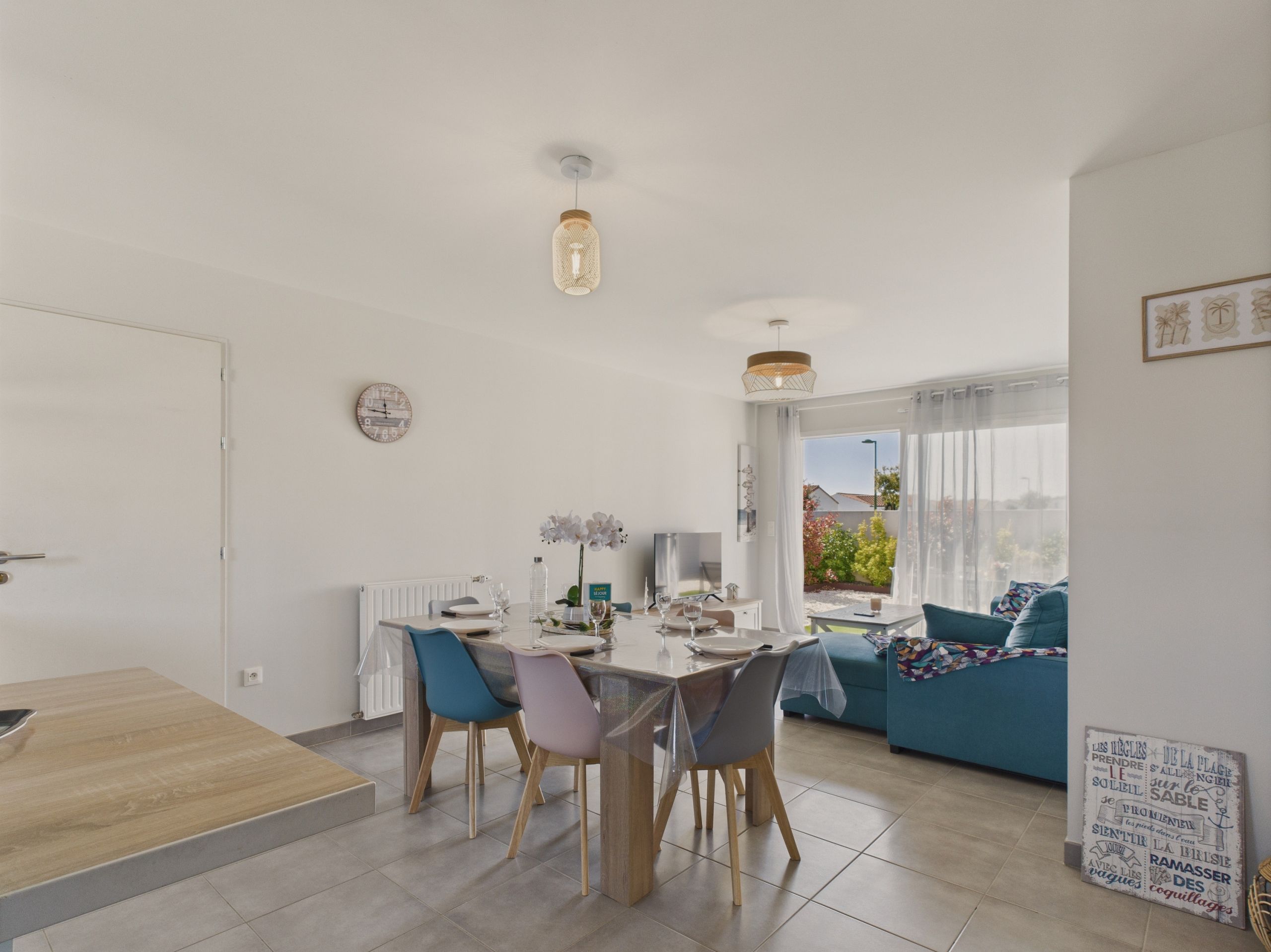 Een moderne woonkamer met een eethoek, een bank en een tafel met stoelen.