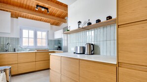 A modern kitchen with wooden cabinets, a white countertop, and a window above the sink. - 200m from the beach-House at Vieil-For 4-Garden (Noirmoutier-en-l´Ile)