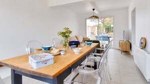 A modern kitchen with a wooden table, clear chairs, and various kitchenware. - 200m from the beach-House at Vieil-For 4-Garden (Noirmoutier-en-l´Ile)