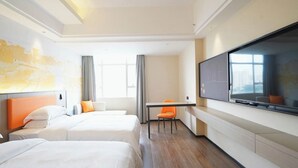 A hotel room with two beds, a desk, a chair, and a large TV on the wall. - yi xuan hotel - bus station (Yangjiang)