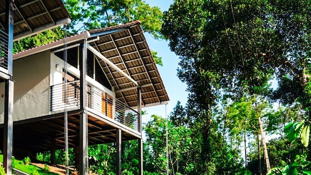 A modern house with a covered porch and a paved driveway. - Eco Vista (Somvarpet)