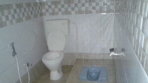 A bathroom with a toilet, bidet, and shower. - Eco Vista (Somvarpet)