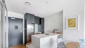 A modern kitchen with a central island, a built-in oven, and a sink.