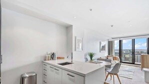 A modern kitchen with a central island, a built-in sink, and a stainless steel trash can.