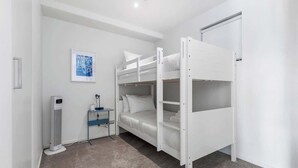 A bunk bed room with a desk and a heater.