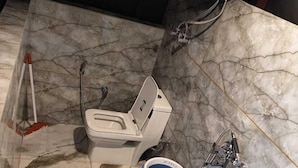 Une salle de bain équipée de toilettes, d’un bidet et d’un chauffe-eau.