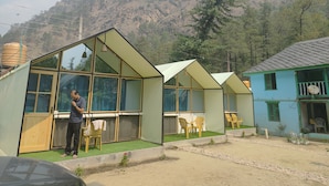 Une série de cabanes modernes aux murs de verre et au toit plat, qui se dressent sur un site offrant une vue imprenable sur les montagnes.