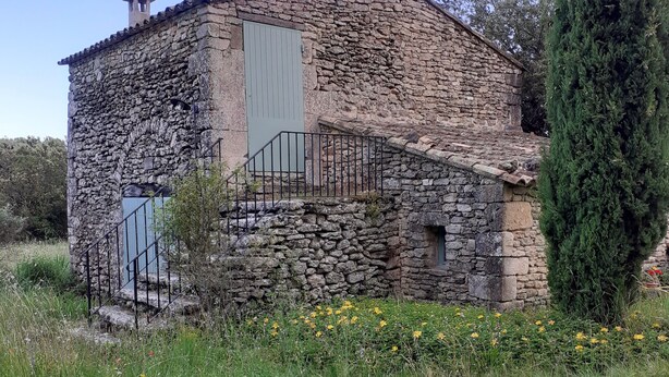 A stone building with a metal staircase and a door.