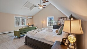 A bedroom with a large bed, a desk, a chair, a lamp, and a ceiling fan. - Cozy Riverfront Stay in Wareham (Wareham)
