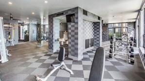 A gym with checkered flooring, exercise equipment, and a mirrored wall. - Houston Gem: Walk to Med Center & NRG (Houston)