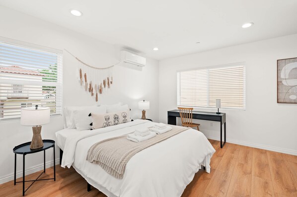 Une chambre moderne avec un grand lit, des tables de chevet, un bureau et une chaise.