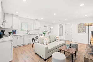 Un salon moderne avec un canapé, une table basse et un coin repas.