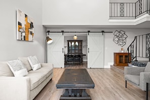 A spacious living area with a sofa, a coffee table, and a dining table. - Luxury Hilltop Stay Pool Views Sleeps Many (Hacienda Heights)