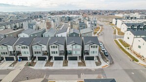 A residential area with modern houses, a main road, and a distant view of mountains. - Near American Fork Canyon | Family & Pet Friendly (American Fork)