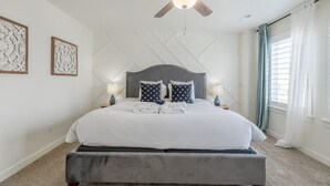 A bedroom with a large bed, a ceiling fan, and two bedside lamps. - Near American Fork Canyon | Family & Pet Friendly (American Fork)