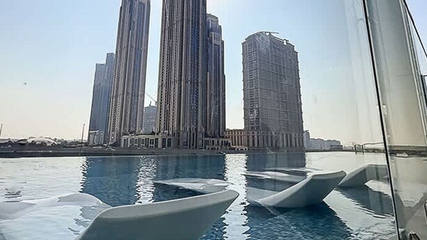 A view of tall buildings with a swimming pool in the foreground. - Homesgetaway-cozy Luxury 1BR I Missoni Urban Oasis (Dubai)