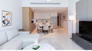 A modern living room with a sofa, a coffee table, and a TV. - Homesgetaway-luxury 2Br Apartment in Beach Vista Tower 2 With Beach Access (Dubai)