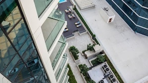 Een modern gebouw met een glazen gevel, een terras en een kleine tuin.