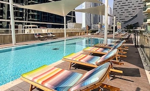 A rooftop pool area with lounge chairs and a view of the city skyline. - 1BR Missoni Apt 5 Mins to Burj Dubai Mall (Dubai)