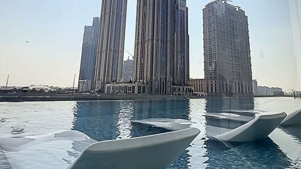 A view of tall buildings with a swimming pool in the foreground. - 1BR Missoni Apt 5 Mins to Burj Dubai Mall (Dubai)