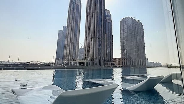 A view of a swimming pool with modern architecture in the background. - Bright Beautiful 1-br Missoni Urban Oasis (Dubai)