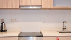 Keittiössä on Bosch-merkkinen liesituuletin, ruostumattomasta teräksestä valmistettu vedenkeitin ja hana, jossa on pesuallas.