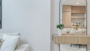 A modern bathroom with a large mirror, wooden vanity, and a white sink. - 2BR Missoni Apt 5 min Drive to Burj Dubai Mall (Dubai)