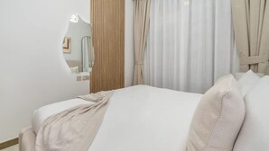 A hotel room with a bed, a mirror, and curtains. - 2BR Missoni Apt 5 min Drive to Burj Dubai Mall (Dubai)