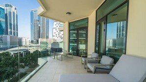 A balcony with a city view, glass doors, and a seating area with a table. - 2BR in Missoni Bldg 5 Mins to Burj Dubai Mall (Dubai)