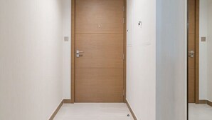 A hallway with a wooden door and a mirror on the right. - 2BR in Missoni Bldg 5 Mins to Burj Dubai Mall (Dubai)