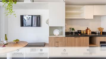 A modern kitchen with a built-in oven, cookware, and a coffee machine.