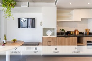A modern kitchen with a built-in oven, cookware, and a coffee machine. - Onze22 by Viva - Estúdios Modernos a 400m do Metrô Vila Madalena com Piscina no Rooftop (São Paulo)