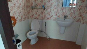 Un baño con inodoro, lavabo y ducha.