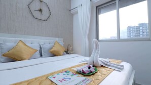 A hotel room with a bed, a welcome mat, and a towel on the bed. - Entire 2 BHK Suite With Kitchen (Mumbai)