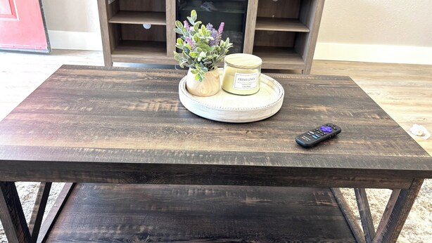 A wooden table with a remote control and a candle on a tray. - Charming  1 bedroom apartment with AC, WiFi in quaint Columbus (Columbus)