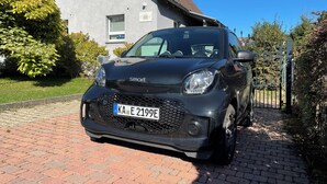 A black car parked in front of a house with a paved driveway. - Minihotel (Pforzheim)