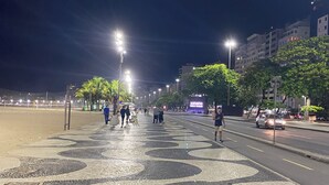 Una calle urbana iluminada por farolas, con pavimento decorado.