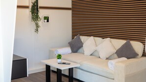 Een moderne woonkamer met een bank, een salontafel en een wand van houten latten.
